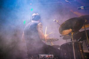 performing drummer surrounded by fogs